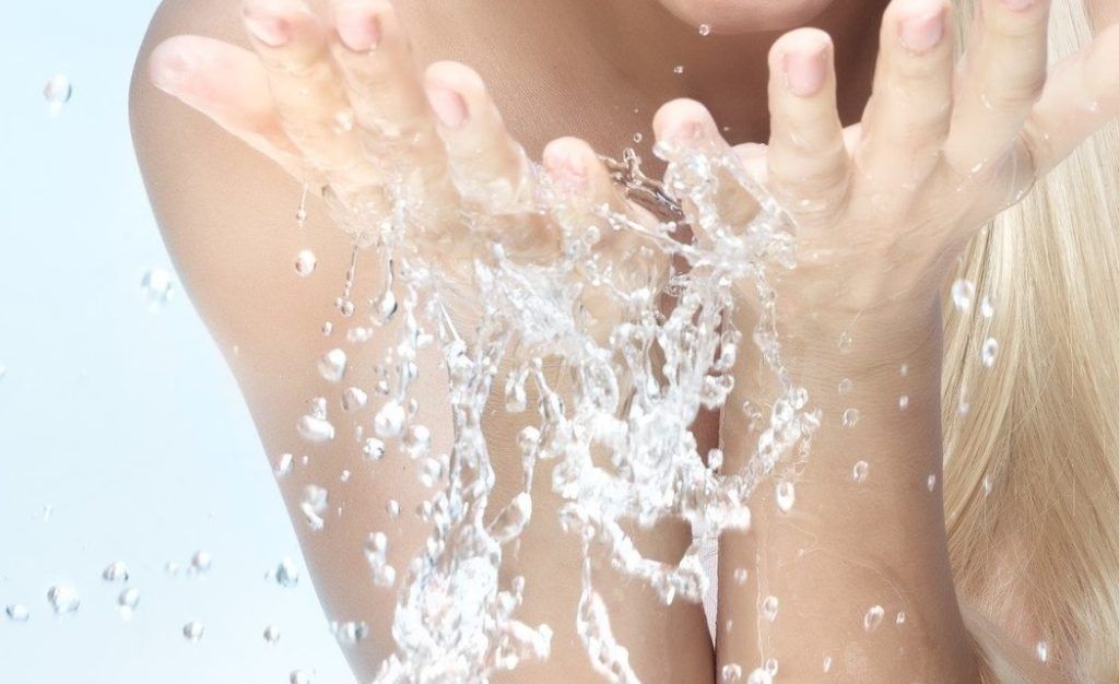 Portrait of a nice excited woman with perfect smile and fresh skin, refreshing her face in the morning with clear cold water, beauty and health care concept, isolated on blue background, Image: 363865144, License: Royalty-free, Restrictions: , Model Release: yes, Credit line: Profimedia, Panthermedia