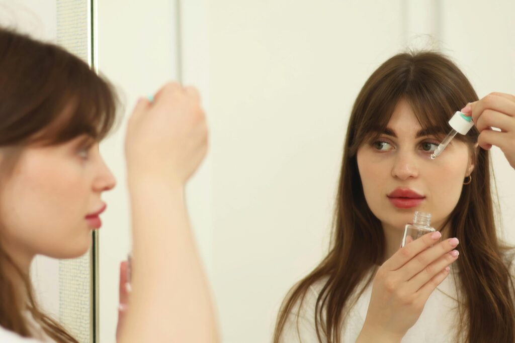 Žena nanosi serum na lice