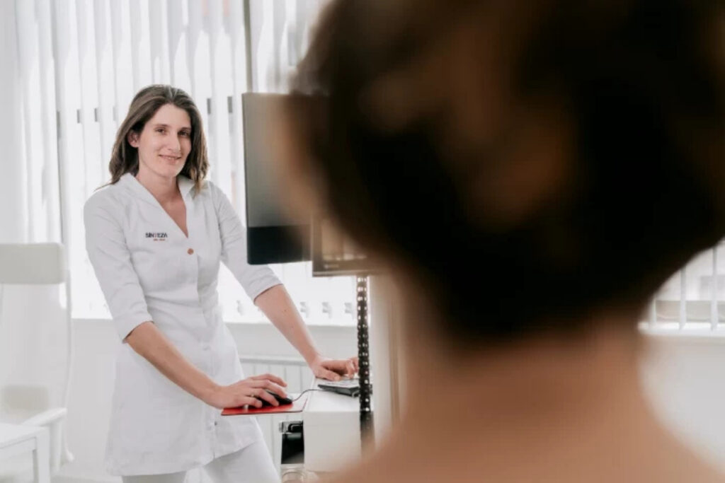 Dermatolog pregledava madeže pacijentice dermatoskopom