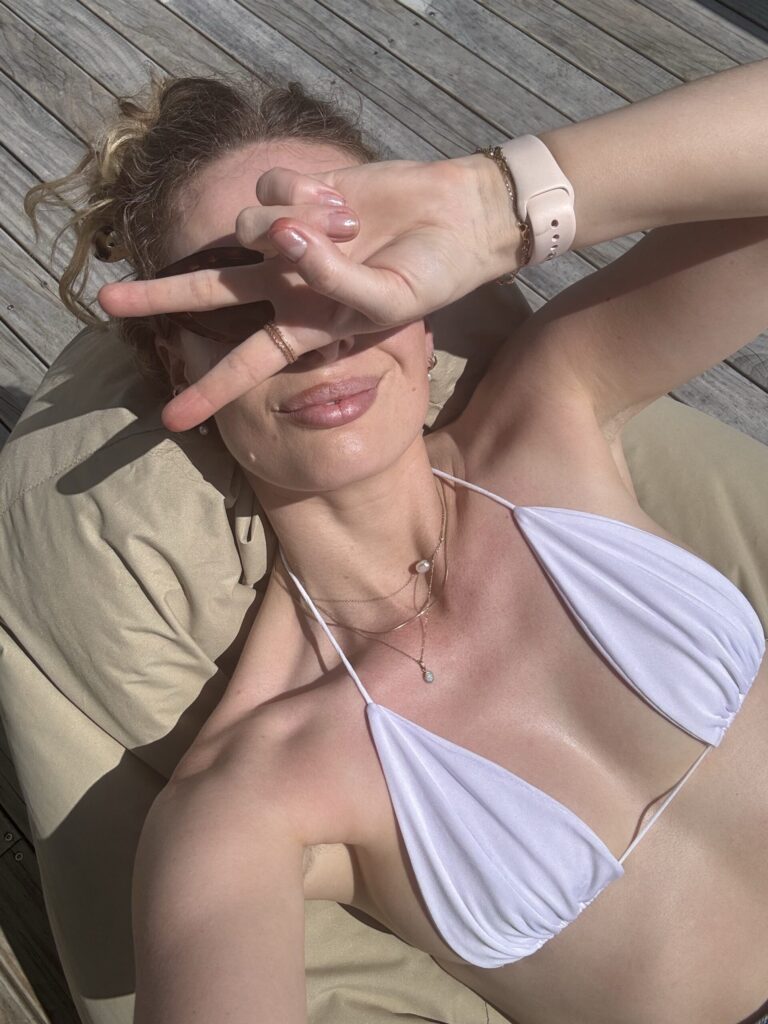 Žena na plaži s prirodno sjajnom i njegovanom kožom