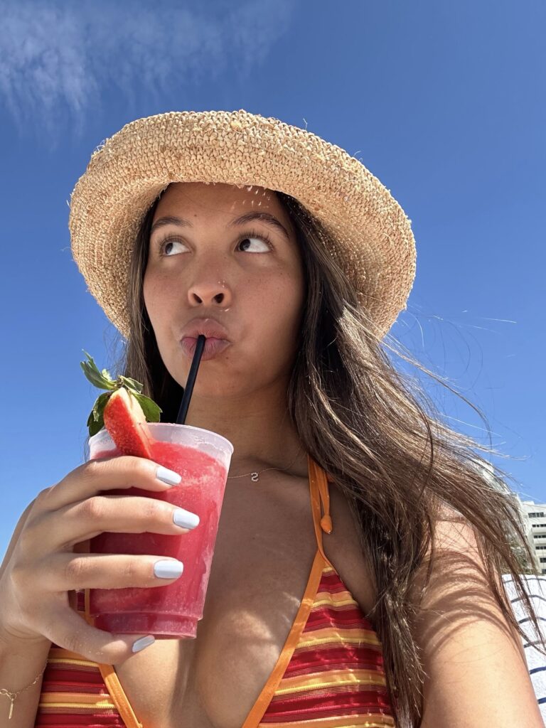 Žena pije sok na plaži ljeto