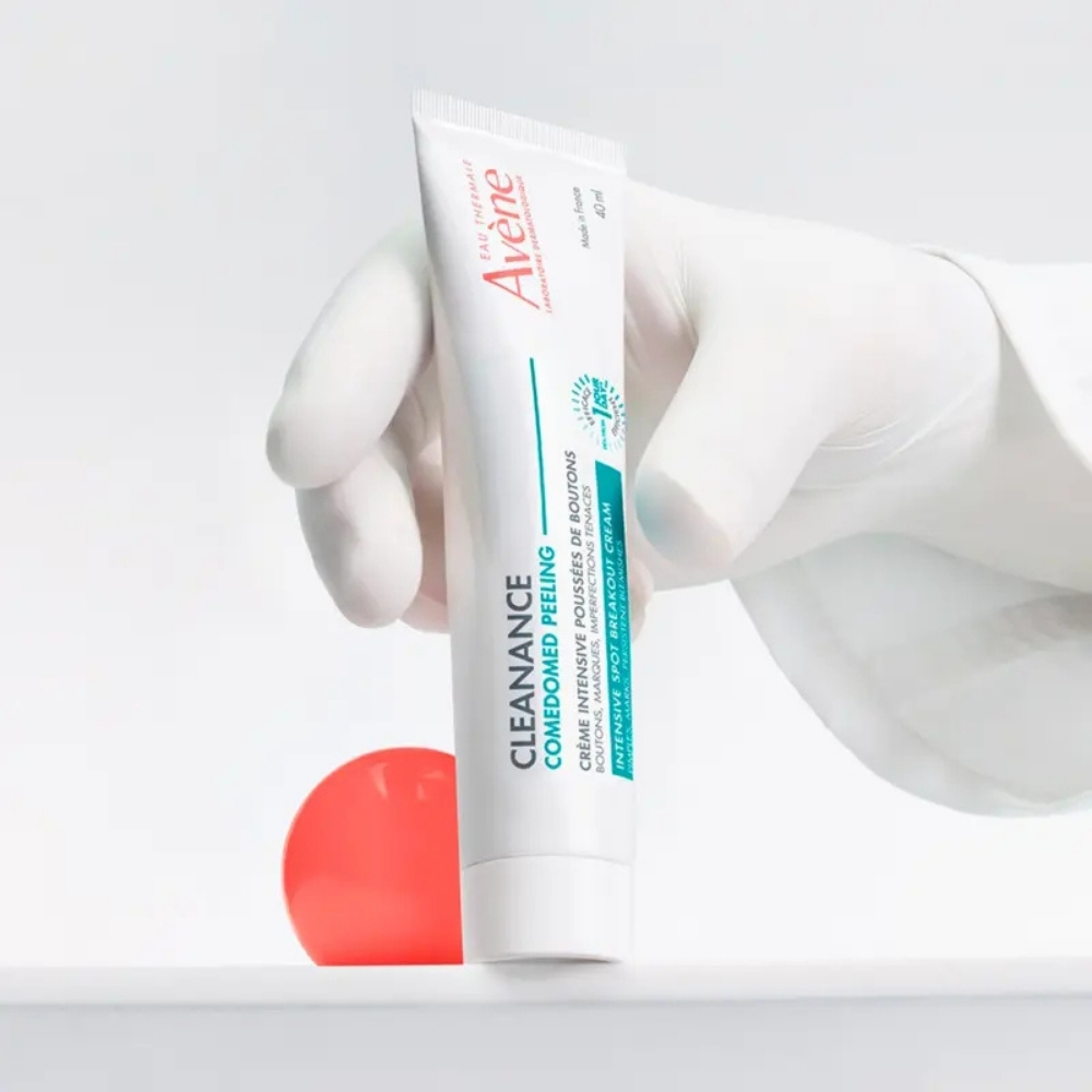 Avène Cleanance Comedomed Piling Intenzivna krema protiv nepravilnosti u ruci u bijeloj rukavici.