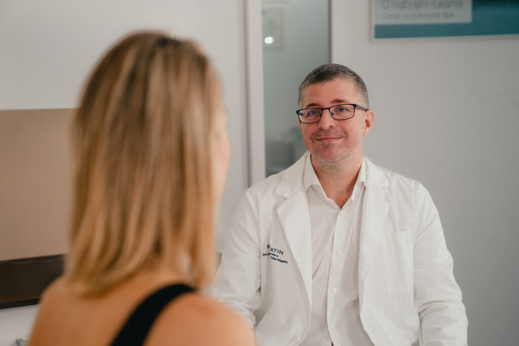 Doc. dr. sc. Dinko Bagatin razgovara s pacijenticom tijekom konzultacija o implantatima za grudi