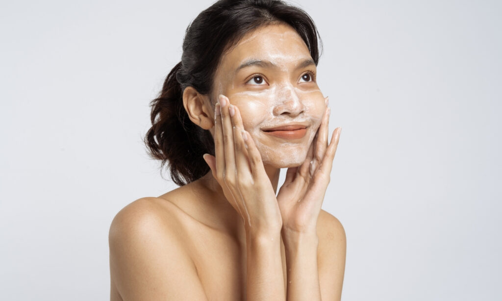 Žena masira pjenušavi gel za čišćenje po licu tijekom svakodnevne skincare rutine.